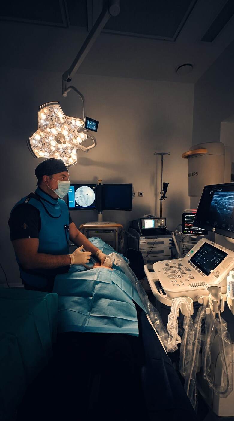 El Dr. Martín Rodríguez Banqueri preparando una infiltración guiada por ecografía en la sala de intervencionismo de Clínica Dolentia; en el monitor del ecógrafo, la imagen de ultrasonido que guía la aguja